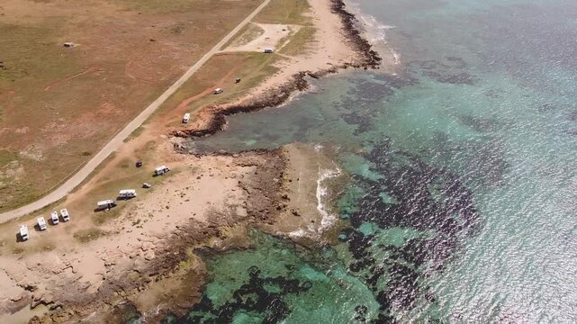 Aerial drone view of Macari (Makari), Sicily. Crystal clear turquoise waters, rugged cliffs, golden sandy beaches. A serene natural landscape with Mediterranean charm near San Vito lo Capo.	