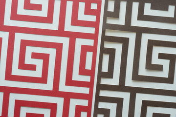 machine-cut red and brown paper meander pattern on blank paper