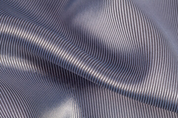 Silk background, texture of gray color, shiny, delicate fabric with irregular folds, close up