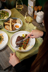 Elegant Dining Experience with Grilled Steak, Roasted Vegetables, and White Wine