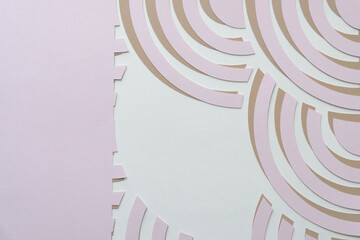 overlapping pink on beige abstract machine-cut paper patterns with concentric arc shapes on blank paper