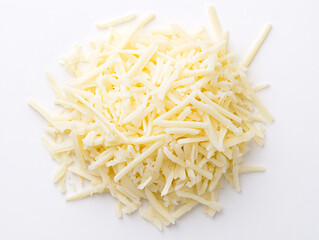 A mound of freshly grated white cheese sits on a plain white surface showing its soft shredded texture and delicate strands  
