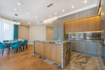 The interior of a modern kitchen. The countertops and floor are decorated with marble. Exclusive furniture.