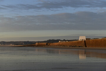 St.Ouen's Bay, Jersey, U.K. Natural Winter beach at sunset with 19th century White guardhouse.