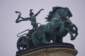 Obraz premium Close up of the statue of a Charioteer holding a snake on a chariot on a Column on Heroes' Square, Budapest, Hungary