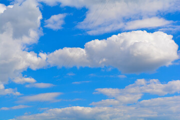 A bright blue sky with fluffy white clouds scattered across. The crisp and clean look of the clouds...