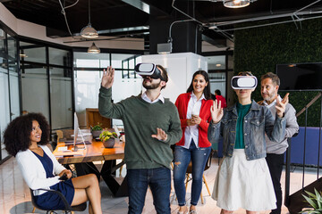 Group of young latin business people using virtual reality glasses during meeting testing VR headset at office in Mexico Latin America. hispanic people at working at job