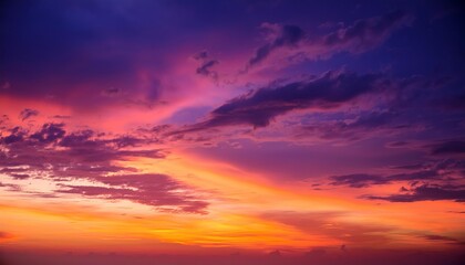 Obraz premium Vibrant sunset painting the sky with hues of purple, orange, and pink over a tranquil landscape in the evening hours