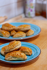 Homemade golden-brown pastries on blue plates
