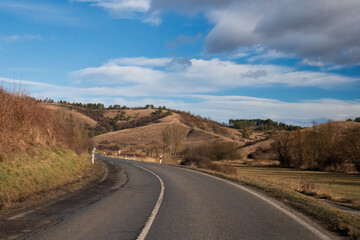 Winding road through rolling countryside hills
