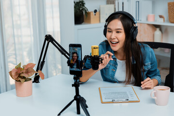Host channel Asian influencer talking in broadcast wearing headsets on social media live on...