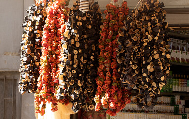 Clusters of dried peppers and eggplants for winter vegetable dishes in a spice market.