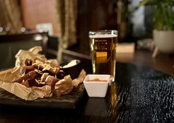 Enjoying Delicious Snacks and Refreshing Beer Arranged Beautifully on a Wooden Table