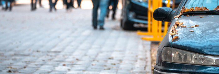 The city in autumn, the leaves on the parked car