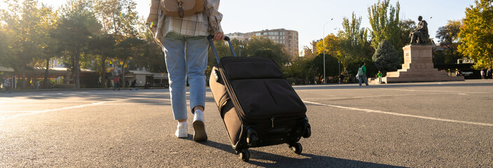 A tourist walks with his suitcase.
