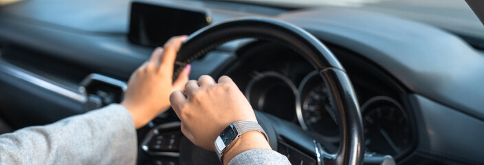 A female driver looks at her watch because she is running late.