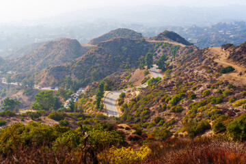 Obraz premium Hikers on Winding Trails with Hazy Cityscape in Griffith Park