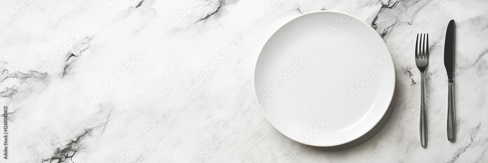 Poster empty white plate with silver fork and knife placed on a marble countertop ready for serving a meal.