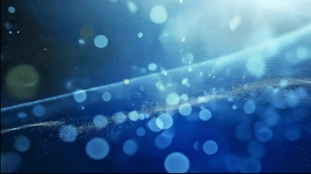 A beautiful abstract close-up of blue bokeh lights and water droplets, creating a dreamy, blurred effect with a touch of elegance.
