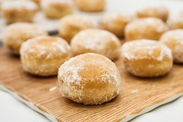 Cream filled buns on a wooden board ready to eat