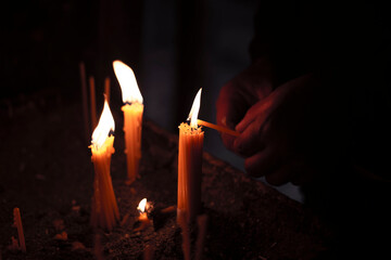 Burning candles in a church on a dark background