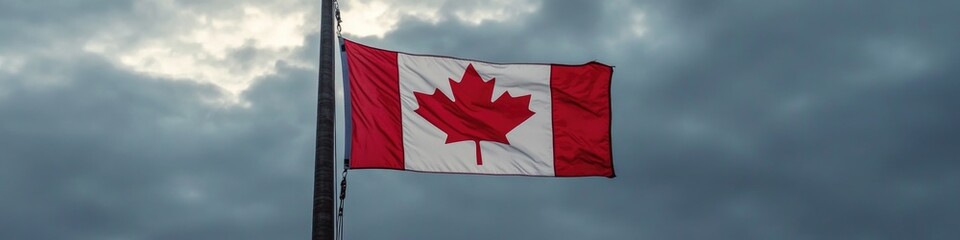 A Canadian flag waving gently in the wind on a cloudy day