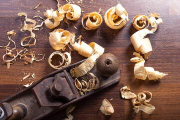 Chisel and antique wood planer with wood shavings