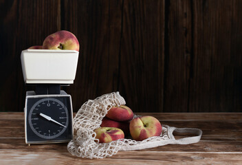 Fresh, ripe Saturn flat peaches are weighed on vintage plastic scales, some spilling out of a...