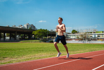 Obraz premium A man runs on a track with a blue shirt and black shorts