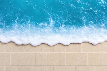 Obraz premium Soft white wave crests on turquoise water, gently lapping a tiled beige surface.