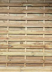The image is a close-up of a wooden wall made up of horizontal wooden planks. The planks are arranged in a grid-like pattern, with each plank having a horizontal line running horizontally across it. 