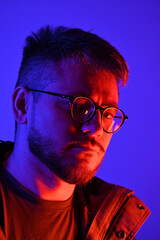 A stylish photo of a young man with blue-pink lighting