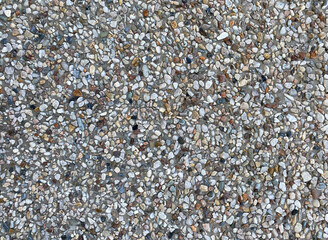 The image is a close-up of a gravel surface. The gravel appears to be made up of small, irregularly shaped pebbles of different sizes and colors. The colors range from light grey to dark grey, with so