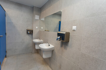 Modern Restroom Featuring Dual Basins, Attractive Hand Dryers, and Sleek Design Elements