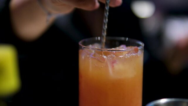 Woman's hand stirs bcaa in a glass, water turns red. High quality 4k footage