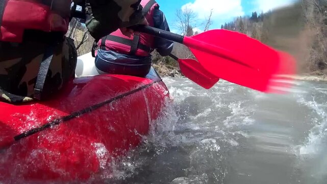 Rafting on a mountain river with a group of people on a raft, view at waterline level