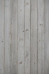 Fototapeta premium a wooden surface, showcasing a vertical layout of four wide planks. The wood has a weathered and rustic appearance, with a predominantly light gray color, interspersed with subtle variations in tone. 