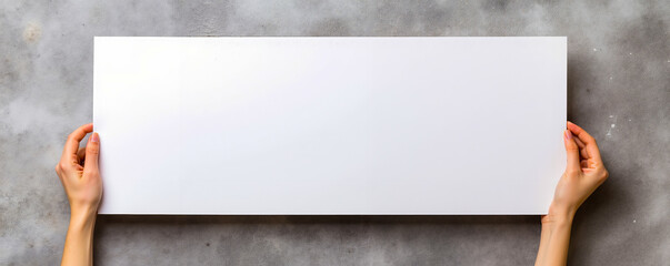 A person holding a blank white board in their hands