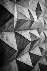 Abstract grayscale image of geometric, three-dimensional, textured, carved, stone, rock, or concrete shapes.