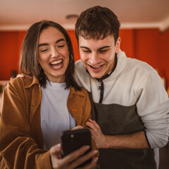 youth couple boyfriend and girlfriend use mobile phone for fun at home