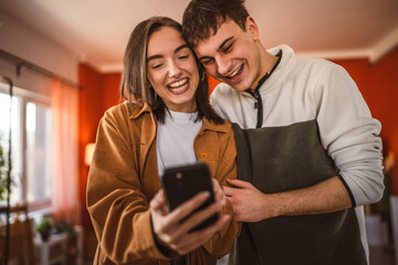 youth couple boyfriend and girlfriend use mobile phone for fun at home