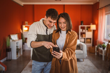 youth couple boyfriend and girlfriend use mobile phone for fun at home