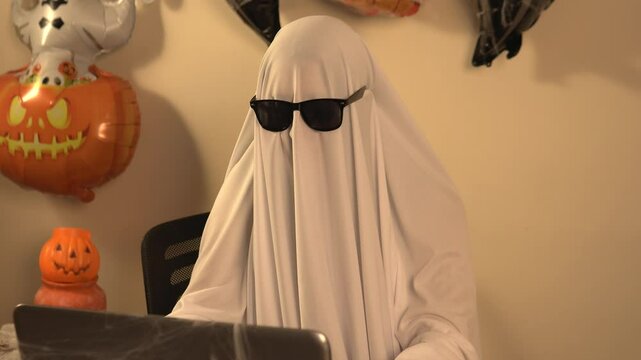Fantasma con gafas de sol trabajando en laptop