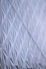 A detailed view showcasing the intricate geometric pattern of a textured wall, emphasizing its abstract aesthetic appeal and symmetry with subtle lighting.