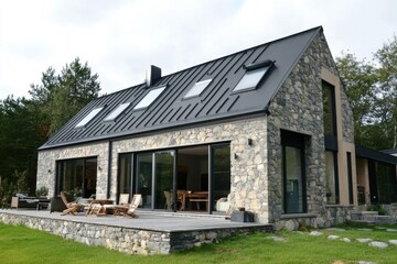 A contemporary stone home featuring expansive windows and an inviting outdoor seating space, beautifully nestled amidst lush greenery in a tranquil environment