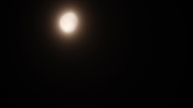 Tokyo,Japan - February 16, 2025: The moon shining beyond the thick clouds.
