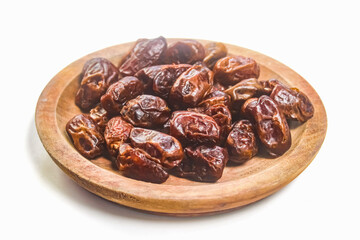 dates in a wooden bowl on a white background