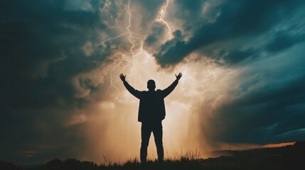 Fototapeta premium Silhouette of man with arms raised during a dramatic lightning storm.
