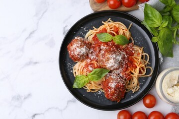 Delicious pasta with meatballs, basil, cheese and tomatoes on white marble table, flat lay. Space for text