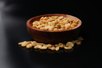 salted broad beans close-up in a wooden bowl. side view, good for recipe or commercial, isolated on black background